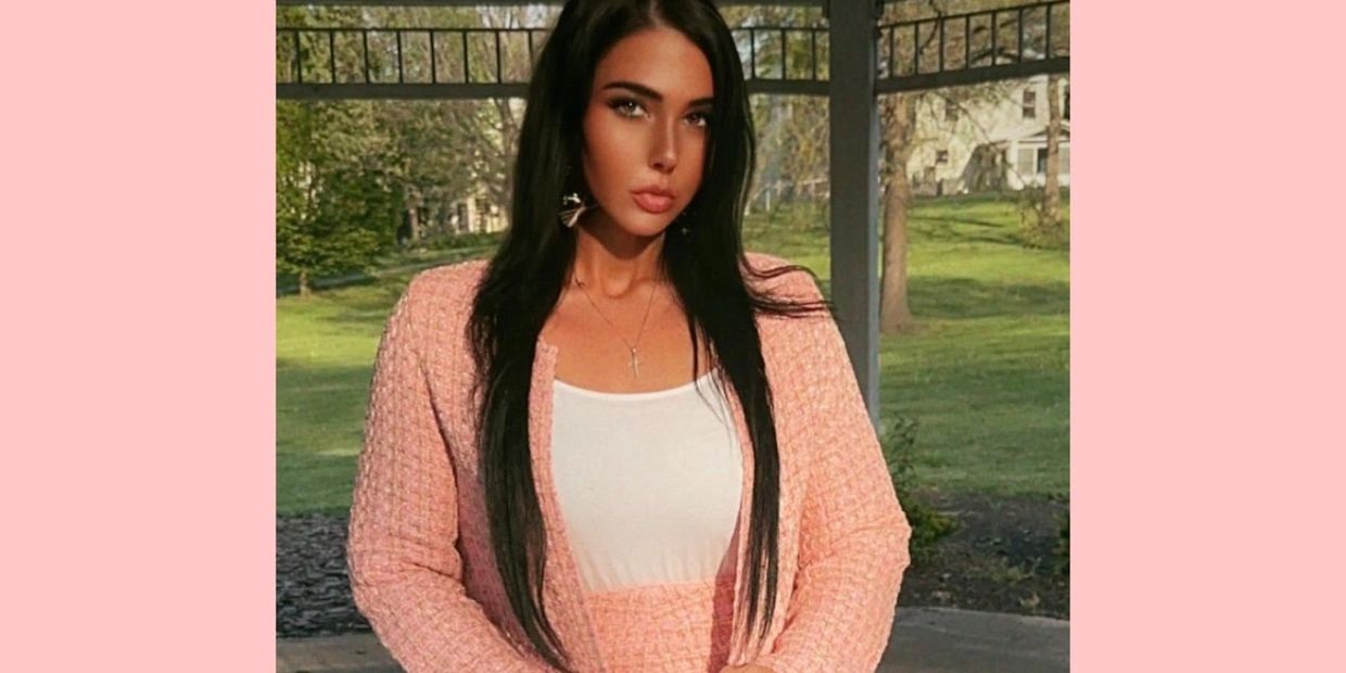 Woman in pink outfit posing outdoors.