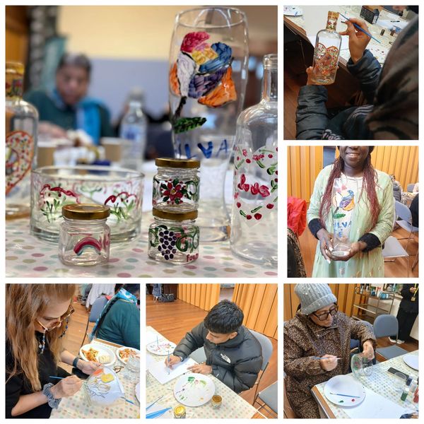 People painting colorful designs on glass jars, bottles, and plates in a workshop.