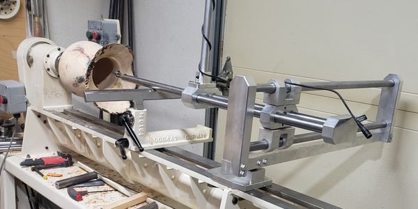 A woodworking lathe with a partially hollowed wooden piece mounted.