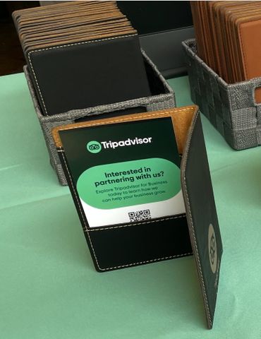 Tripadvisor business partnership brochure displayed on a table with card holders.