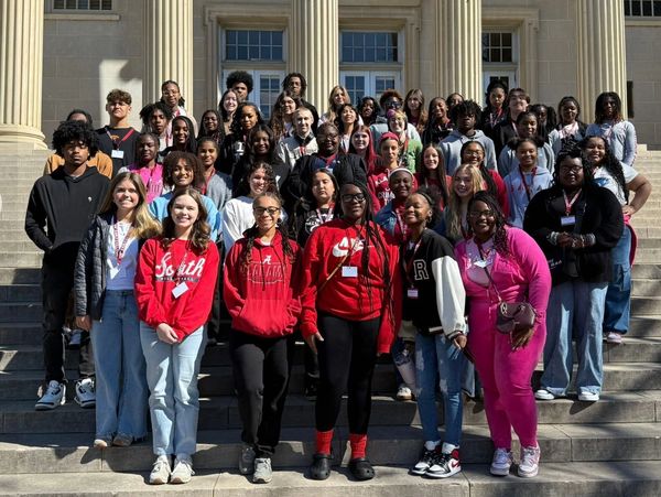 Large group of diverse students posing on building steps.