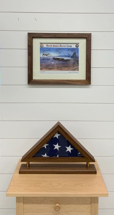 Flag display case on end table with matching walnut certificate frame on white shiplap.