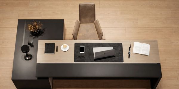 Minimalist modern office desk with laptop, coffee, and open book.