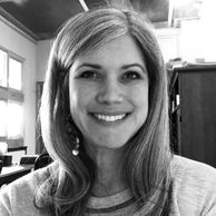 Smiling woman with long hair in a cozy indoor setting.