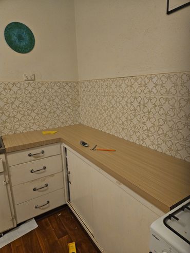 Vintage kitchen corner with patterned tiles and wooden countertop.