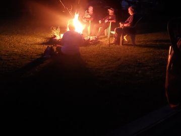 People sitting around a campfire at night.