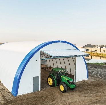 Diamond Bi-Fold Door that is showing in the open position with a tractor coming out of the building