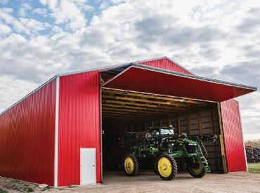 Diamond Bi-Fold Doors on a large red Agricultural building with a John Deere tractor coming out