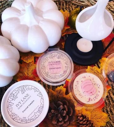 Autumn-themed home fragrance setup with white pumpkins and pinecones.