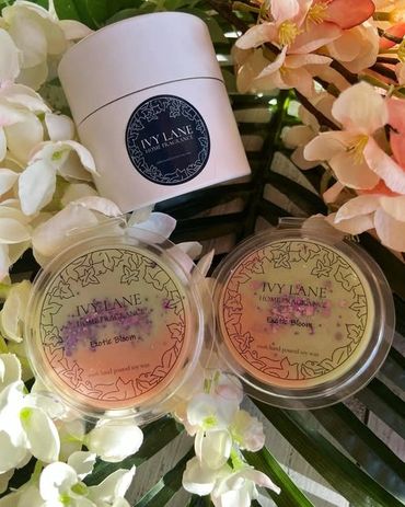 Ivy Lane Exotic Bloom scented wax melts surrounded by flowers.