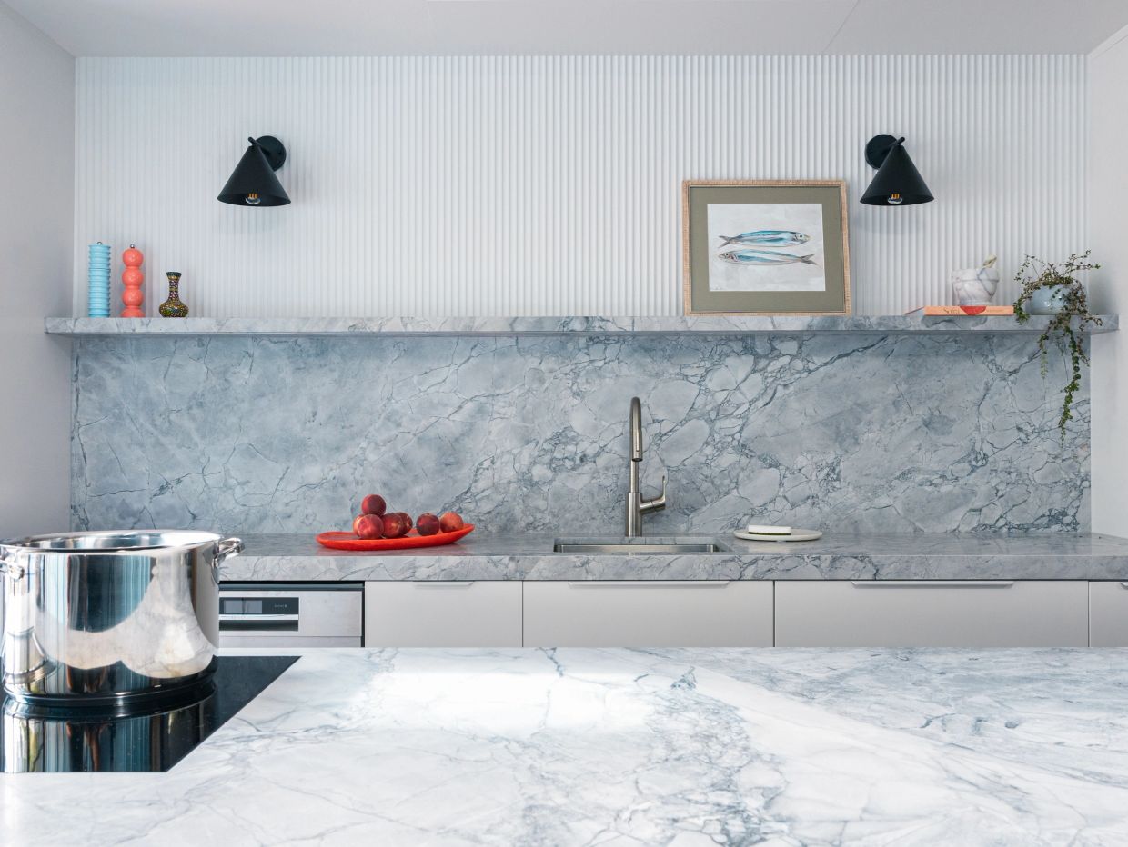 Modern kitchen countertop with marble finish and decorative items.