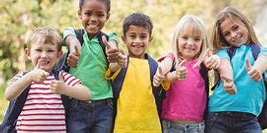 Group of five kids smiling and giving thumbs up.