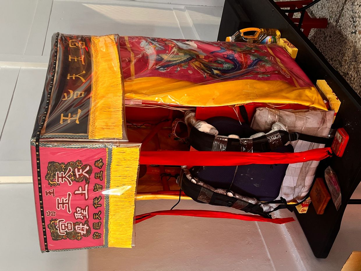 A colorful traditional Chinese palanquin with intricate designs and Chinese characters.