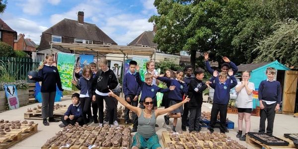 Schoolchildren enjoy a workshop outside in the sun at Bilborough Arts Festival