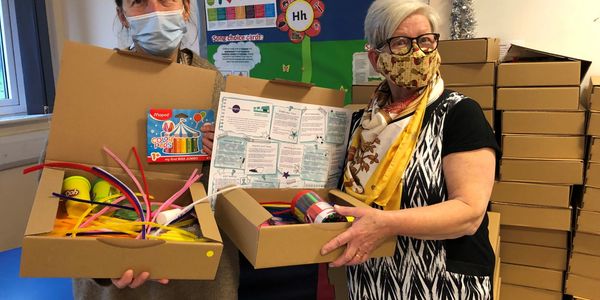 A lady displays the contents of crafts cupboards boxes