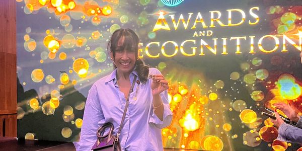 Smiling woman receiving an award at Plannet Marketing event