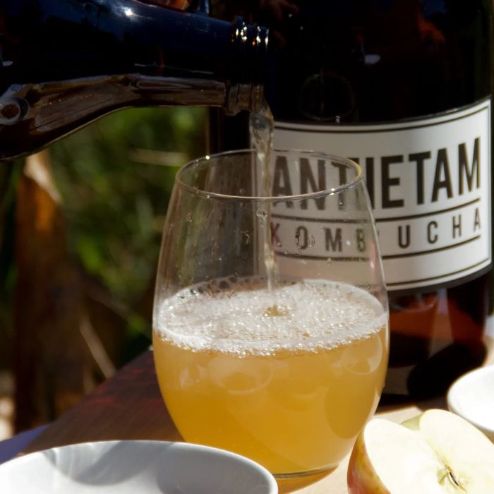 Pouring an ambrosial glass of our Mom's Apple Pie kombucha. 