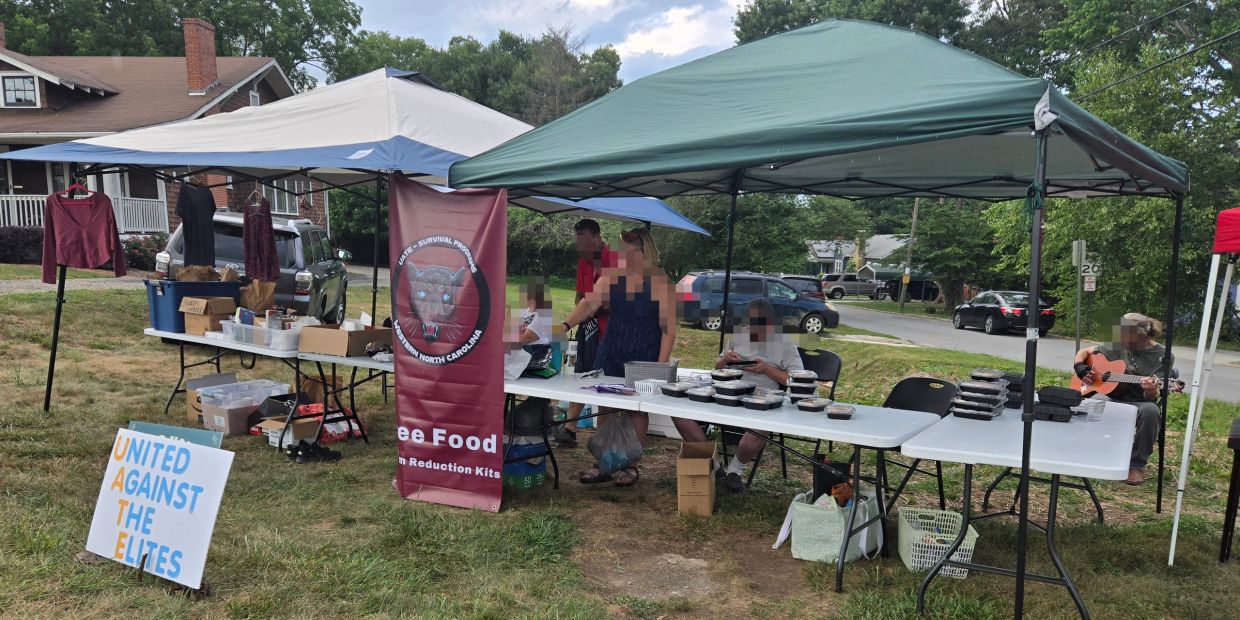 Community outreach event with free food and clothing under tents.