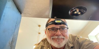 Nick from Nutterman's Appliance Repair service looking under glass cooktop repair in Shawnee, KS