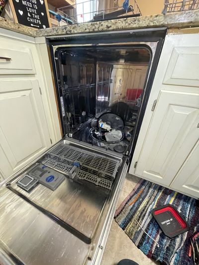 Whirlpool dishwasher being repaired with door open having the spray motor and sump replaced for leak