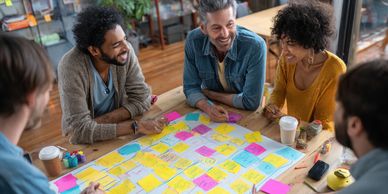 Diverse group of people around a table discussing sticky notes