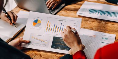 Paper with graphs with hand pointing to graph