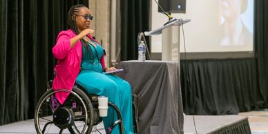 Mia Morris on stage presenting at CONVERGE event in 2023