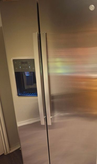 Stainless steel side-by-side refrigerator with water dispenser.