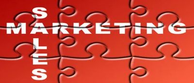 Puzzle pieces with 'MARKETING' and 'SALES' words intersecting.