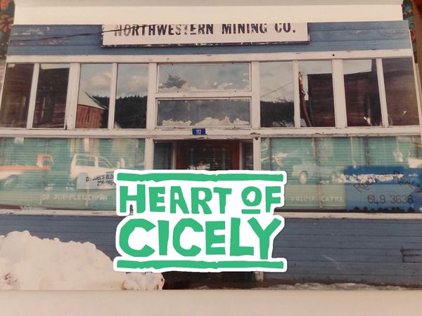 Old Northwestern Mining Co. building with snow and Heart of Cicely text.