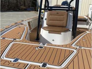Boat deck with brown cushioned seat and teak flooring.
