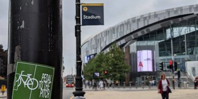 A Pedal to the Pitch sticker on a lampost outside the Tottenham Hotspur Stadium