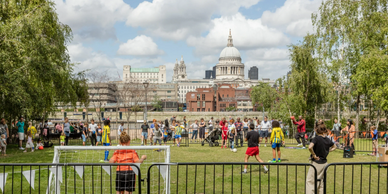 Children playing football on the Thames with St Pauls in the background
