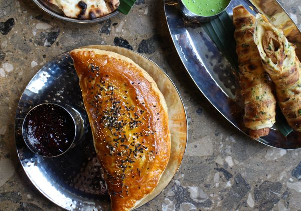 Golden pasty filled with spicy chicken and kebab roll with green chutney