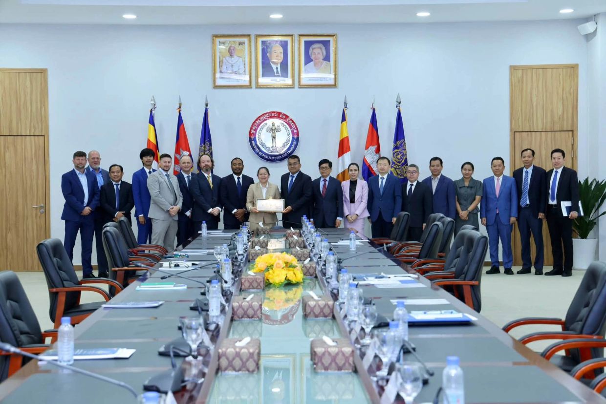 Group of officials posing in a conference room.