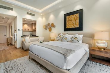 Cozy modern bedroom with neutral tones and warm lighting.