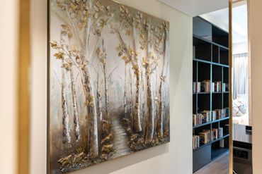 Textured painting of a birch tree forest with golden leaves in a hallway.