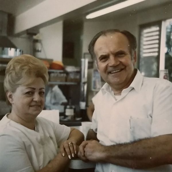 Smiling older couple holding hands in a cozy setting.