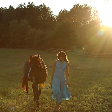 Young girl with horse on farm.