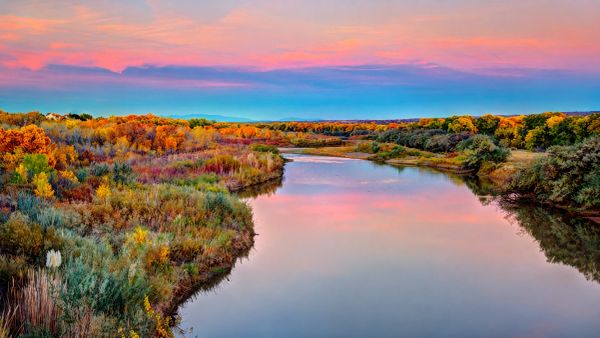 The Rio Grande river in New Mexico during sunset, with a pink and blue sky.
