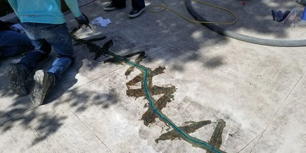 Concrete crack repair on a driveway prior to overcoating