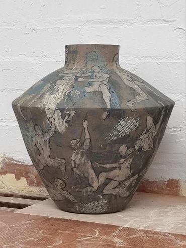 30mm tall clay urn decorated with drawing s of Gods battling mortals. Glazed, awaiting final firing.