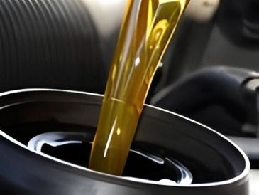 Engine oil being poured into a vehicle's oil reservoir, showcasing the smooth flow of golden liquid.