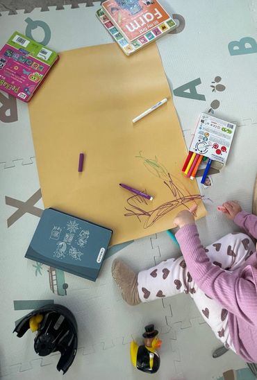 Child coloring at home with the supervisor of our babysitter