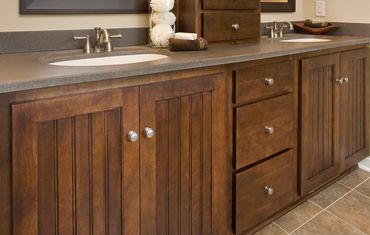 Wood-toned bathroom with curated items above the upper cabinets.