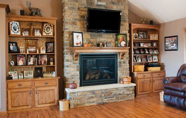 Modern living room with fireplace, bookshelves, and TV.