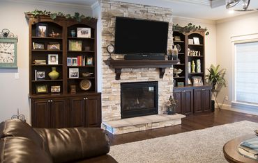 Cozy fireplace with built-in bookshelves and mounted TV.