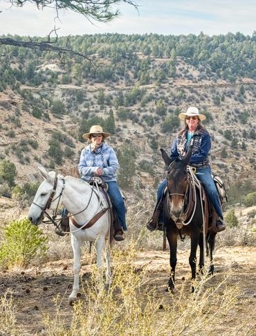 Two women sit on mules on the Rock Springs ride in southern Utah
