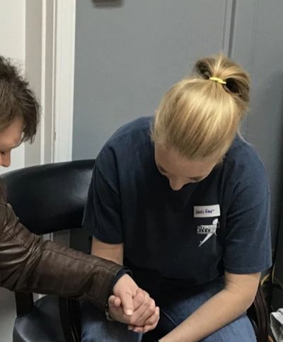 Praying woman holds hand of young woman in need, "Please, help me with this fear and substance use."