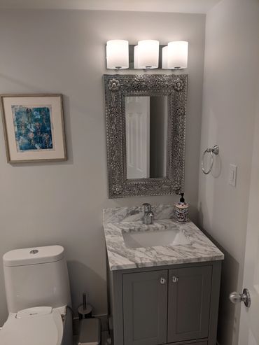 Contemporary bathroom remodel featuring soft grey tile, sleek fixtures, and a minimalist vanity